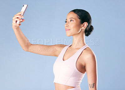 Buy stock photo Studio, fitness and woman with smile for selfie, profile picture and post on social media or memory. Blue background, athlete and happy person on break after exercise, photography and wellness vlog