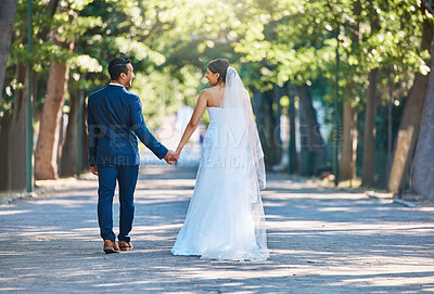 Buy stock photo Couple, wedding and holding hands at park with smile for celebration, walk and back in spring. People, marriage and happy with commitment, connection or love for partner for milestone at urban garden