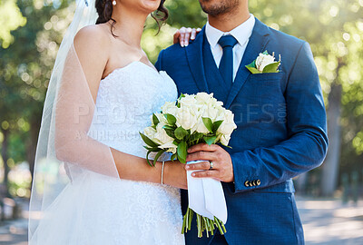 Buy stock photo Couple, wedding and hands with bouquet at park for celebration, bride and embrace in spring. People, marriage and flowers with commitment, connection or love for partner for milestone at urban garden
