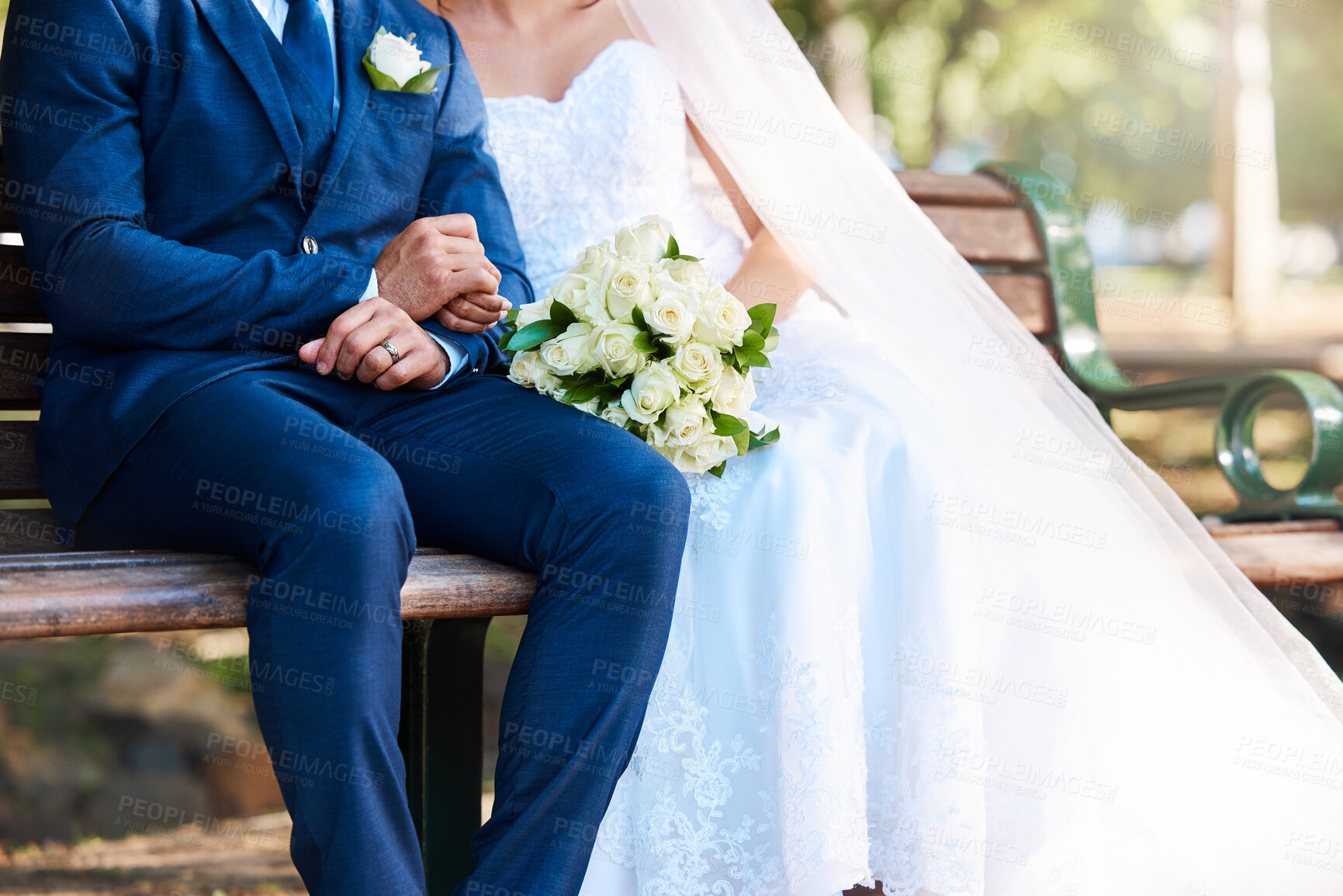 Buy stock photo Wedding, couple and holding hands with bouquet at park bench for commitment, loyalty or love. People, groom and bride with flowers outdoor for marriage ceremony, vow celebration or relationship union