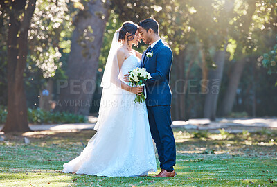 Buy stock photo Happy couple, wedding and hug at park with flowers, touch forehead and relationship in spring. People, marriage and smile with commitment, floral bouquet or care with embrace for milestone at garden