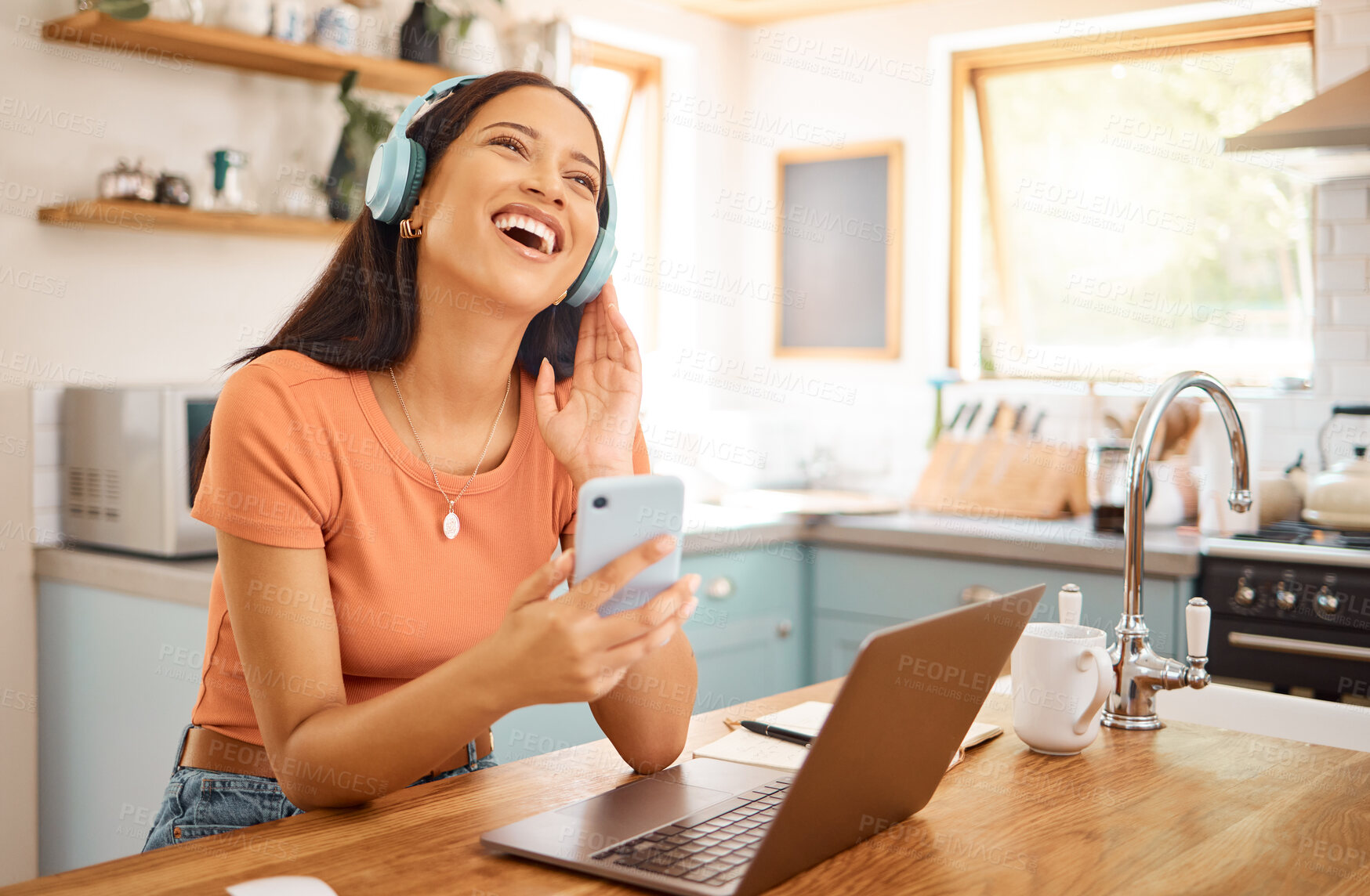 Buy stock photo Woman, laughing and headphones with phone in kitchen for music, break and funny podcast with happiness. Song, radio comedy and female person with cellphone, audio tech and subscription in home