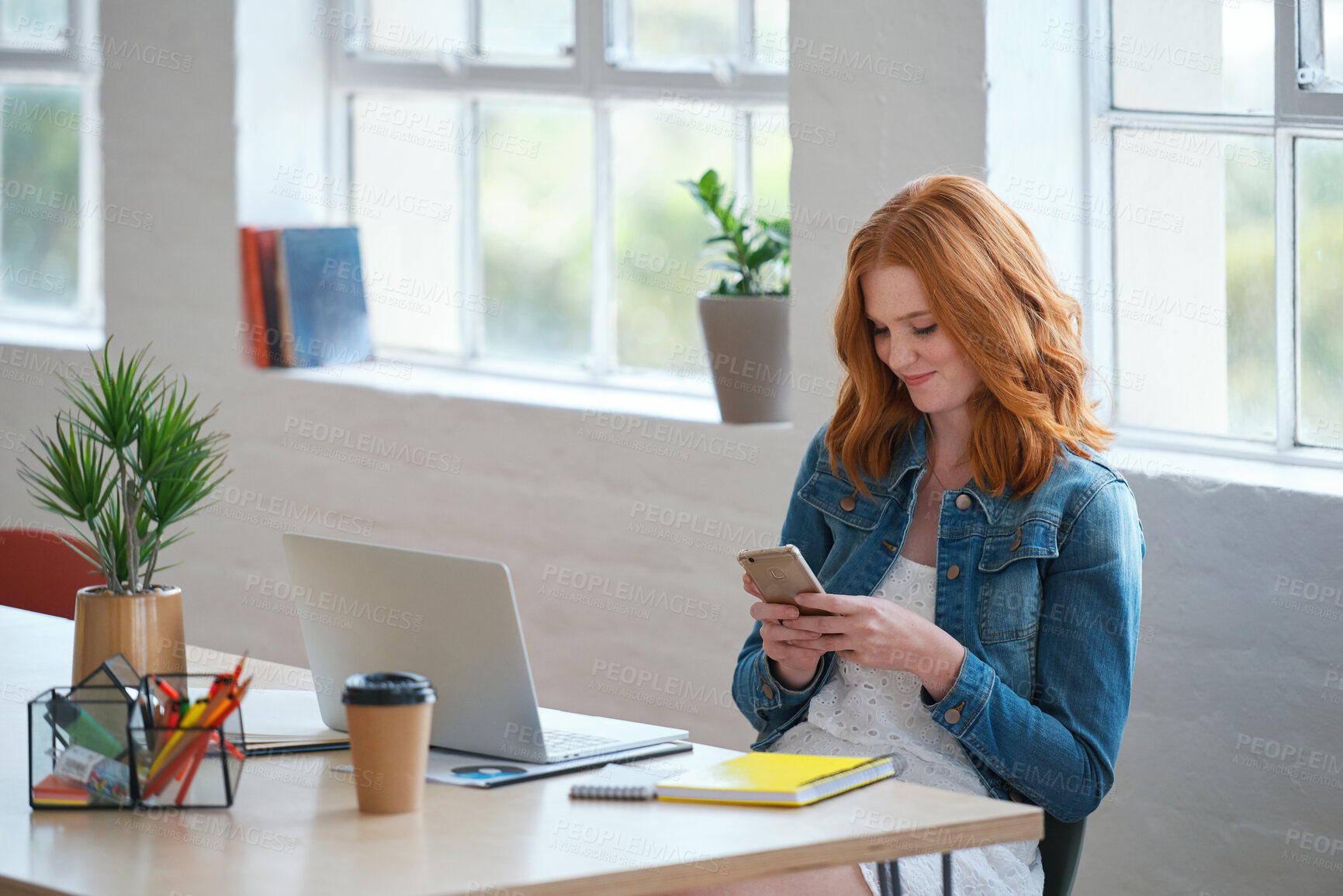 Buy stock photo Design, phone and typing with woman in office for creative career, feedback or project update. App, laptop and text message with designer at desk in artistic workplace for communication or search