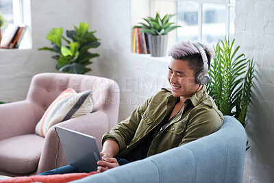 Buy stock photo Laptop, headphones and Asian man in home for music, streaming video or watch show on internet. Computer, person and listening to audio in living room, movie and relax with podcast for happiness