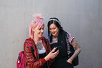Stylish women students using smartphone punk girls browsing social media mesages urban millennials in city