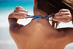 Beautiful young woman ties her bikini