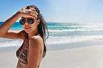 Fashionable woman wearing sunglasses and a bikini on the beach