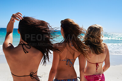 Buy stock photo Back, wind and women on beach in bikini swimwear for holiday, travel or vacation together. Breeze, summer and view of horizon with friends outdoor in nature for coastal break, getaway or trip
