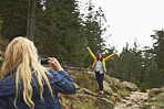 Girl taking photo of friend with smart phone for social media on travel adventure beautiful forest landscape