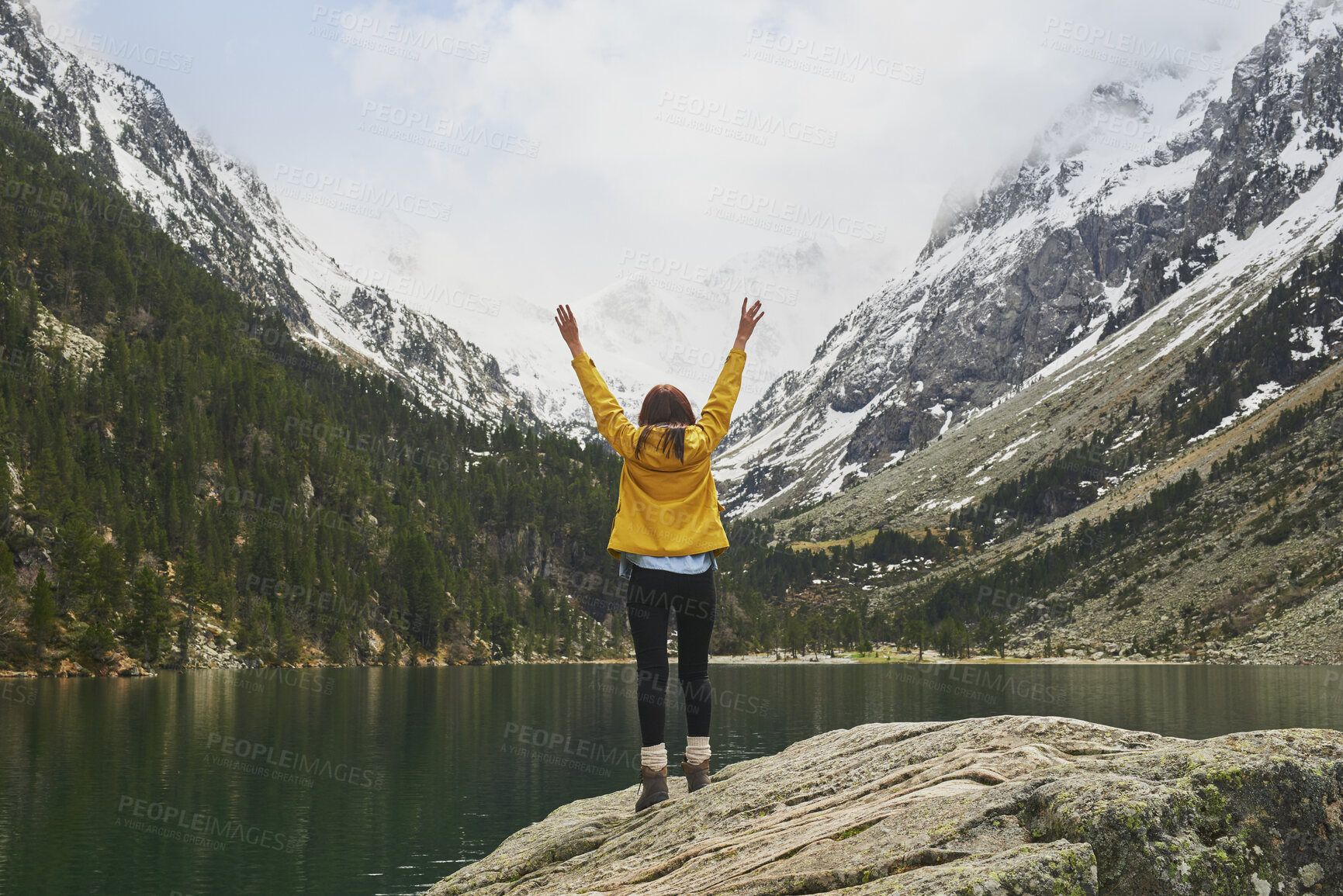 Buy stock photo Lake, mountains and person with back for celebration, success or hiking achievement. Travel, wellness or hiker in nature with arms up for winter journey, adventure or exploration by snow and water
