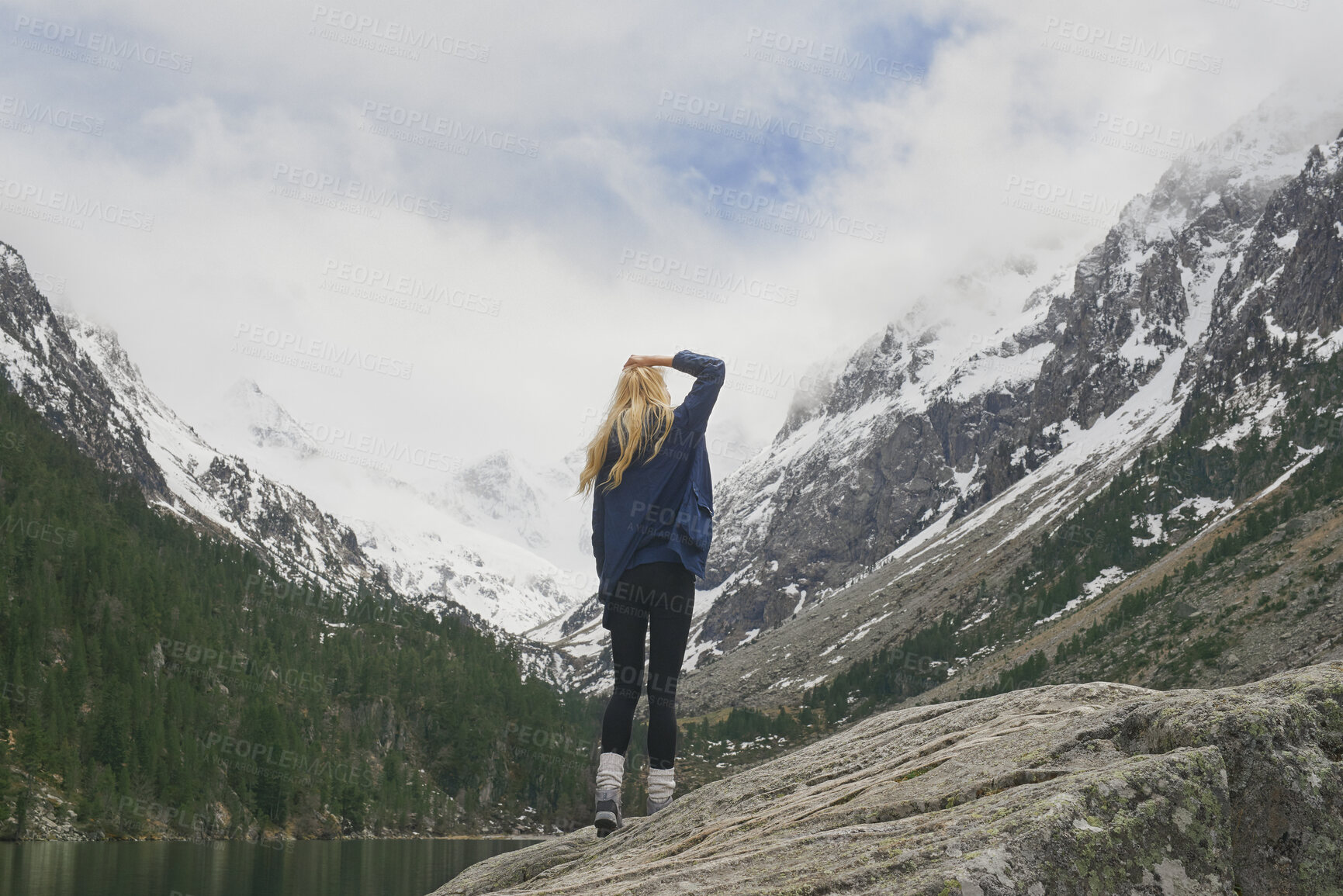 Buy stock photo Winter, woman and hiking with mountain, snow and sightseeing exploration for outdoor adventure trip. Back, female person and peace in nature with scenic view, cold climate and travel for vacation.
