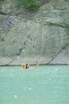 Girl friends taking smart phone selfies swimming in beautiful blue freshwater river on travel adventure