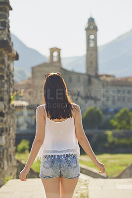 Buy stock photo Woman, tourist and sightseeing with city building for outdoor holiday, vacation or resort. Back view, female person or traveler walking in urban town or settlement for tourism attraction or landmark
