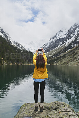 Buy stock photo Woman, phone and hiking in nature for photography, social media post and mountain lake. Space, back and person with mobile for profile picture update, trekking adventure and memory of outdoor river