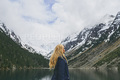 Buy stock photo Winter, woman and hiking with mountain, lake and sightseeing exploration for outdoor adventure trip. Back, female person and peace by river with scenic view, cold climate or snow for travel vacation.