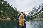 Travel adventure woman taking smart phone photograph on mountain lake enjoying beautiful nature landscape wanderlust