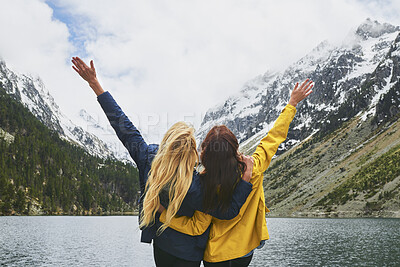 Buy stock photo Hiking, friends and celebration with mountain view in nature for adventure achievement by lake. Freedom, back and women outdoor for trekking success, conquer or accomplishment together for travel