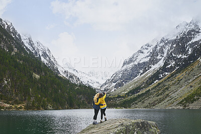 Buy stock photo Trekking, friends and women with selfie by lake on adventure, memory and hug by mountain. Hiking, back and people with picture for nature photography, social media post or travel together with space