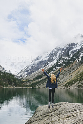 Buy stock photo Lake, mountain and hiker with arms up for success, celebration or hiking achievement. Travel, nature and person on cliff with back for winter journey, adventure or exploration for snow and water