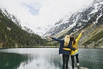 Travel adventure hiker woman friends celebrate on mountain lake arms outstretched enjoying beautiful nature landscape wanderlust