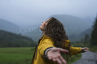 Buy stock photo Woman, freedom and arms raised in nature with rain, fresh air or happy for travel adventure on weekend. Female person, relax and peace outdoor with winter holiday, cold climate and wellness on trip.
