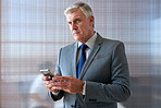 Mature businessman using smartphone in office texting on mobile phone