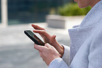 Close up hands business woman using smartphone in city texting on mobile phone 