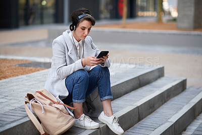Buy stock photo City, phone and businesswoman with music, headphones and text message on morning commute. Travel, employee or person outdoor with mobile for podcast, streaming app or browsing internet with audiobook