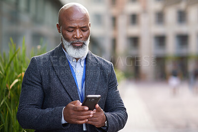 Buy stock photo Mature, phone and business man in city for work commute, communication and travel with typing. Black person, cellphone and texting or message to contact for feedback, space or serious outdoor