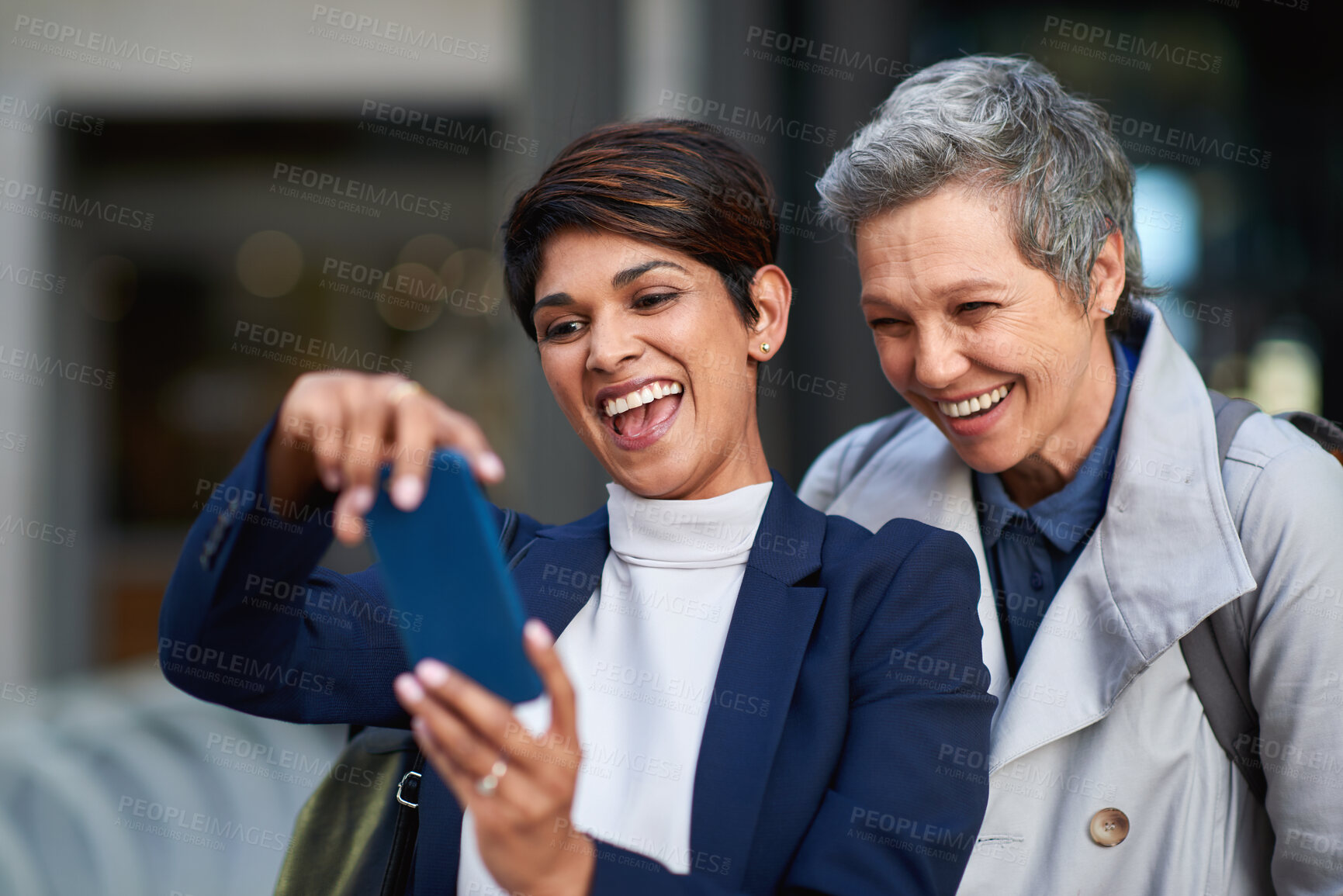 Buy stock photo Phone, laugh and business women in city for social media, commute and morning communication online. Travel, conversation and friends with tech for smile, humor or funny joke and networking or bonding