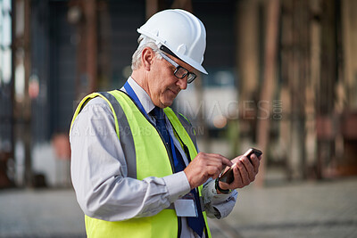 Buy stock photo Construction, phone and typing with mature man outdoor for project management or update. App, research and text message with contractor on building site for architecture, civil engineering or contact