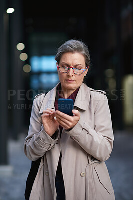 Buy stock photo Business, phone and mature woman outdoor for work commute, communication and travel. Professional person, cellphone and serious texting or message to contact for feedback, network or city