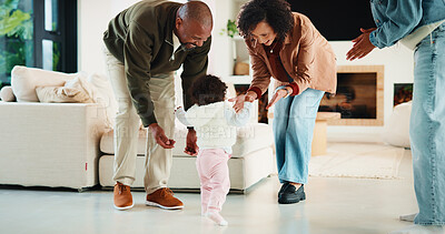 Buy stock photo Parents, baby and excited for first steps in lounge with support, applause or milestone in family home. People, mother and father with children, infant and motivation for walking in living room