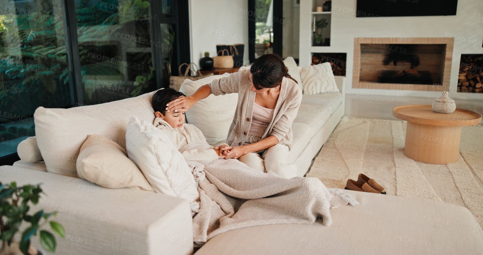 Buy stock photo Sick child, care and mother in home to check temperature, love and holding hands for support. Mom, disease and boy in living room with cold, virus infection or help with fever for health risk on sofa