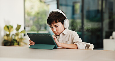 Buy stock photo E learning, headphones and child in home with tablet, online activity or project on academic app. Homeschool, tech and boy in kitchen with homework, digital lesson or assessment in remote education