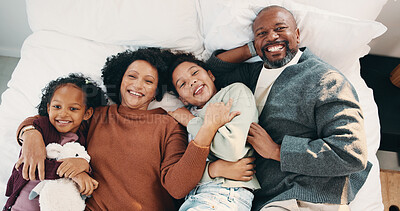 Buy stock photo Portrait, cuddle and parents with children in bed, support and affection for relationship development. Above, African family and happy people with girls for connection, bonding and teddy bear in home