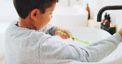 Buy stock photo Basin, toothbrush and water with kid in bathroom of home for morning routine or oral hygiene. Brushing teeth, cleaning and dental with boy child in apartment for health, prevention or wellness
