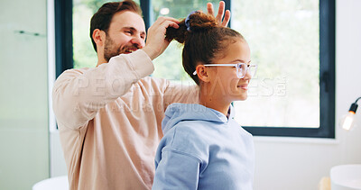 Buy stock photo Bathroom, father and helping daughter in home for haircare or morning routine on weekend. Family, love and single parent man tying hair of girl child in apartment for getting ready or support