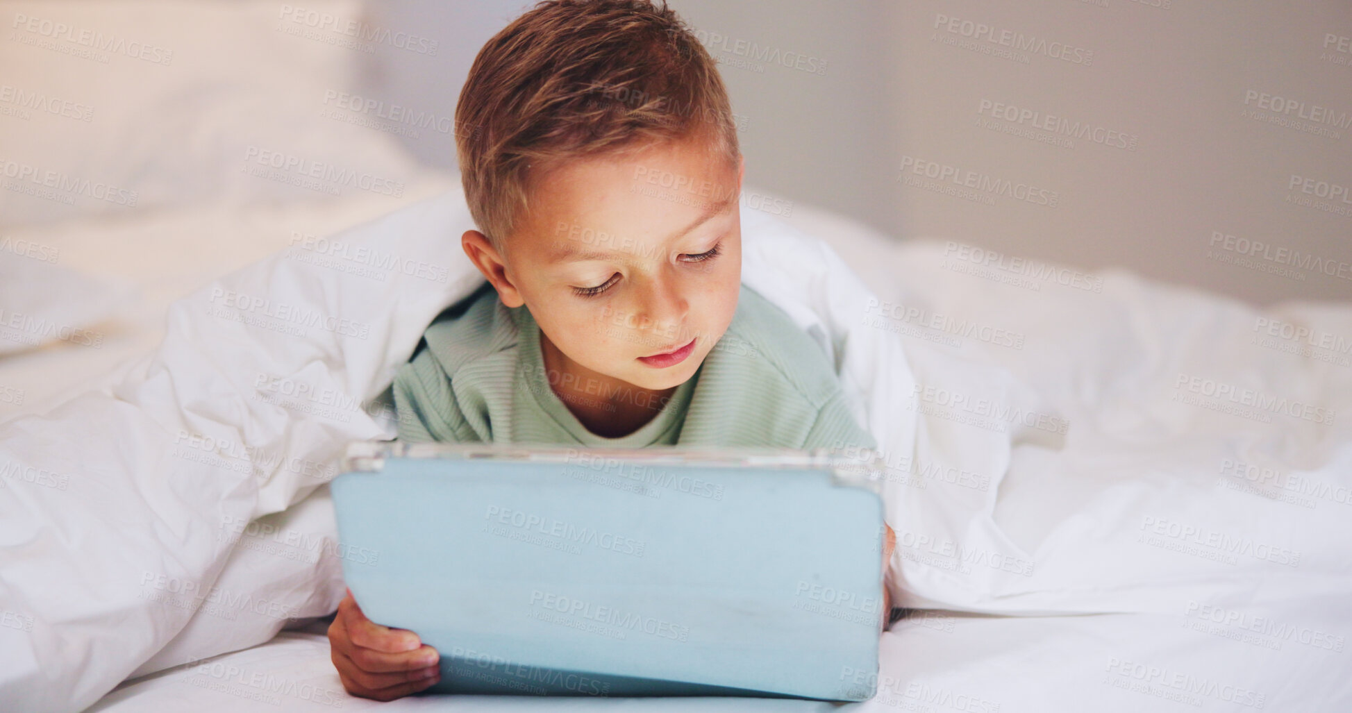 Buy stock photo Learning, child and relax in bed with tablet, puzzle game or online platform for language development. Boy kid, tech and network in home for multimedia, educational app or memory challenge on website