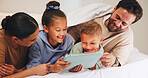Love, tablet and parents with kids in bedroom to relax together, watch cartoon or online show. Tech, mother and father with children at family home for bonding, movie and streaming series with smile