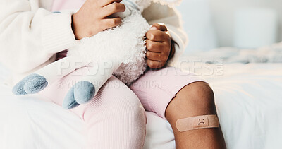 Buy stock photo Plaster, child and hands in home with first aid for wellness, wound protection and toy for comfort. Sad emoji, teddy bear and kid with bandage for injury healing process, health and recovery support