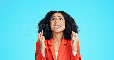 Buy stock photo Praying, woman and fingers crossed in studio with stress for promotion, deal or feedback. Wish, person or worker with luck emoji for anxiety, nervous or waiting for announcement on blue background