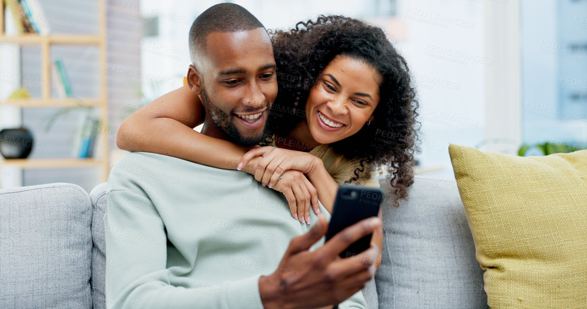 Buy stock photo Hug, couple and laugh with phone on sofa for internet meme, social media video and bonding. Love, african people and happy with mobile app in home for funny online post, relationship or weekend break