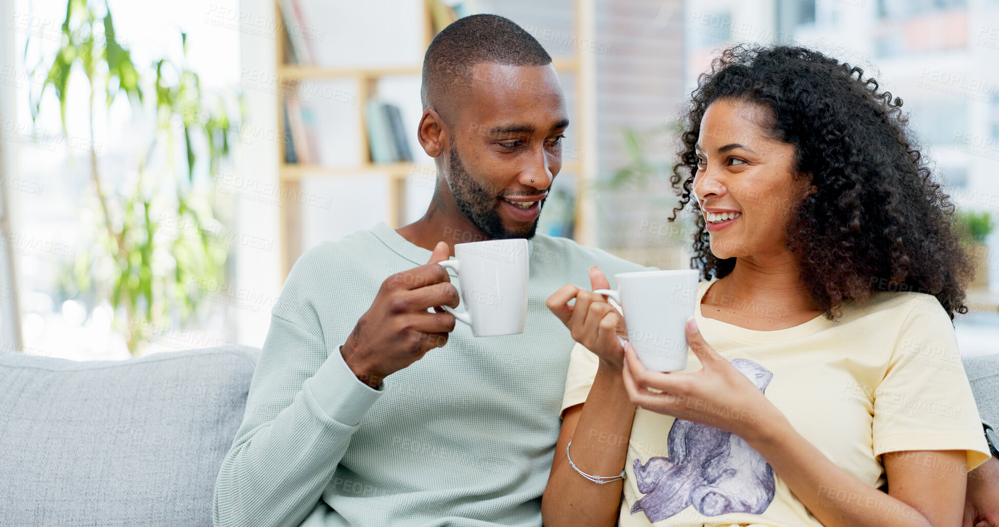 Buy stock photo Couple, happy and coffee on sofa with talk, story and memory with bonding in living room. African people, discussion and drink with smile, conversation and connection with relationship at apartment