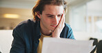 Paperwork, debt and man in home with stress for financial challenge, bankruptcy or rent increase. Document, expenses and person at house with crisis for loan, bad credit or reading info for bills