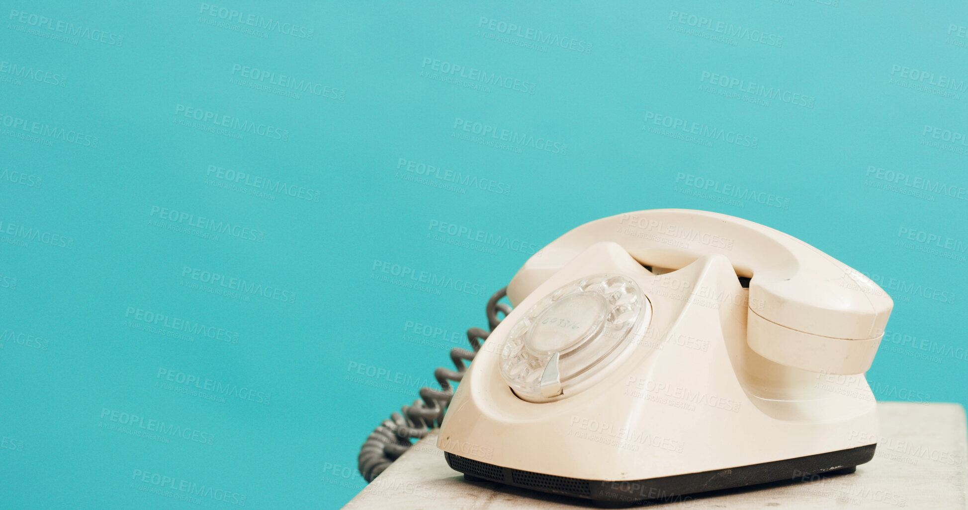 Buy stock photo Studio, space and retro telephone for communication, connection or contact on blue background mockup. Table, rotary landline and iconic technology for history, vintage design and classic dial