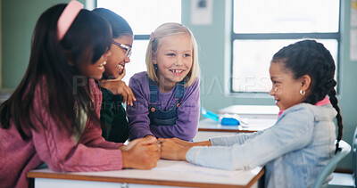 Buy stock photo Classroom, friends and girl in school, talking and sharing information for homework at desk. Happy, students and children bonding for education, knowledge and learning together with group project