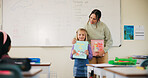 Girl, teacher and reading book in classroom for learning, teaching and language development. Literature, story and student with woman for support, presentation and education in confidence at school