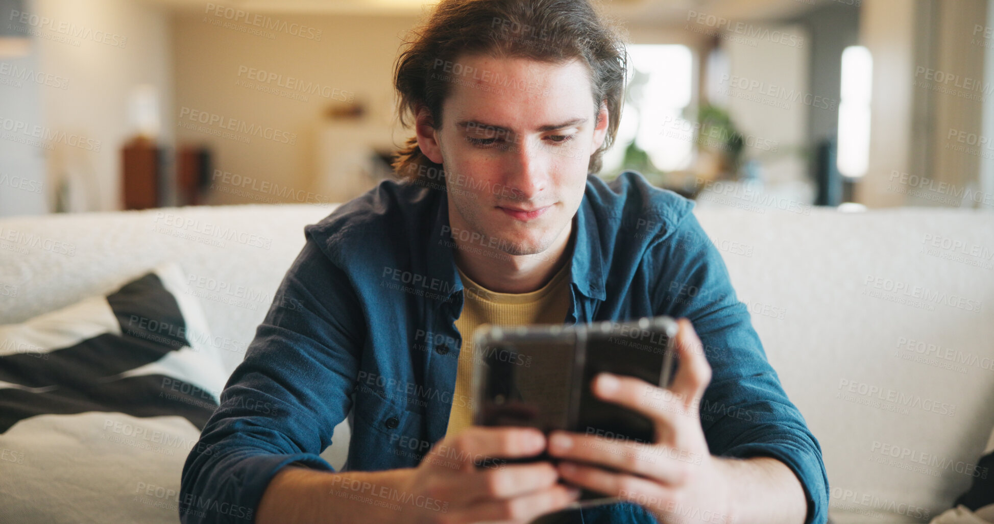 Buy stock photo Reading, man and scroll with phone in home for texting with contact, app and social media. Thinking, person and chat with digital tech in living room for online, typing message or website in lounge