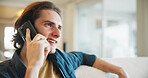 Phone call, talking and man in living room of home for smile with discussion, contact or networking. Happy, communication and person with digital tech for conversation, relax or chat in lounge